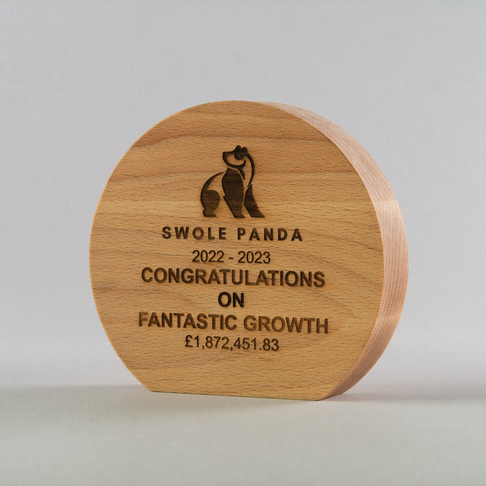 Wooden plaque with engraved text and Swole Panda logo on a light gray background