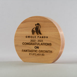 Wooden plaque with engraved text and Swole Panda logo on a light gray background