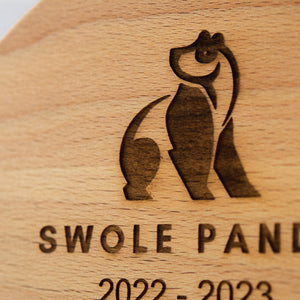 Wooden plaque with 'Swole Panda' logo and text on a wooden background