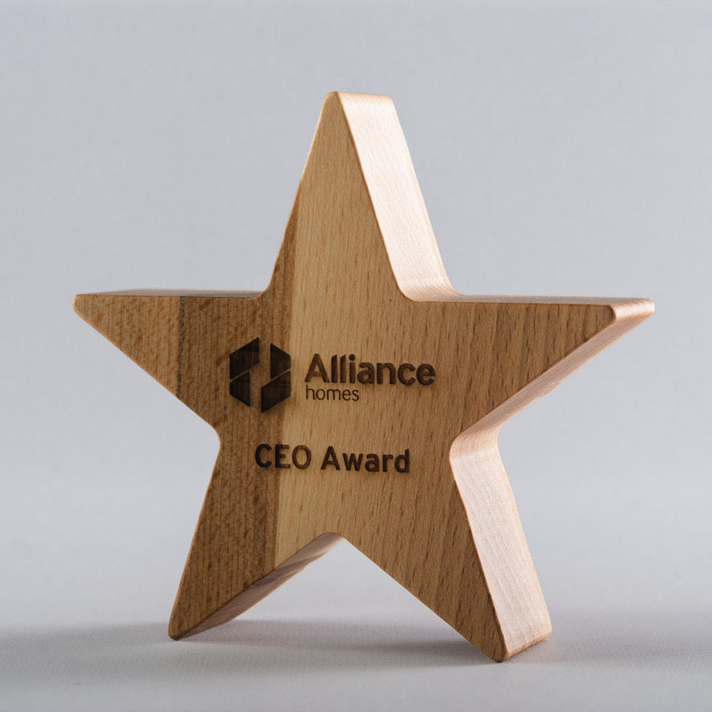 Wooden star-shaped award with 'Alliance homes' logo on a gray background
