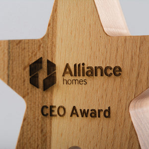 Wooden star-shaped award with 'Alliance homes' logo and 'CEO Award' text on a light gray background