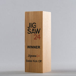 Wooden block with 'Jigsaw 24' branding on a gray background