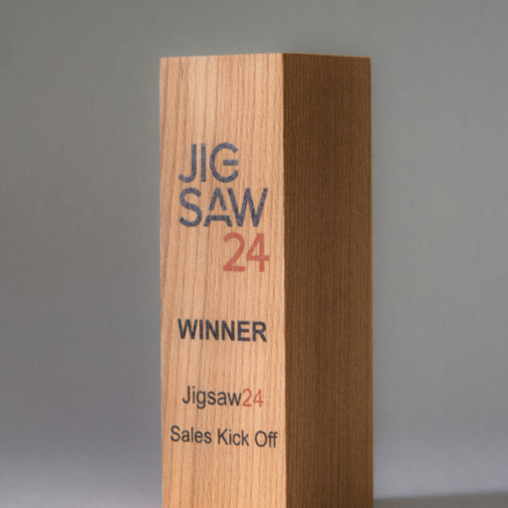 Wooden award with 'JIG SAW 24' branding on a gray background