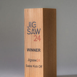 Wooden award with 'JIG SAW 24' branding on a gray background