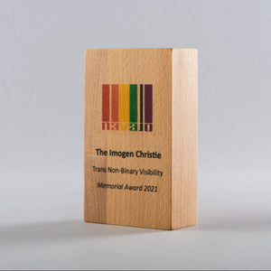 Wooden award with engraved text and logo on a gray background